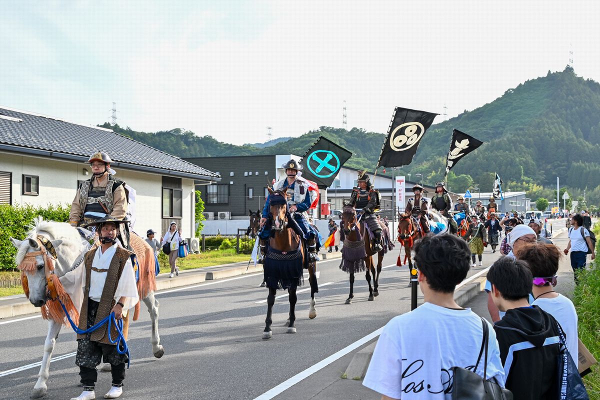 沿道沿いの観覧者に見守られながら凱旋する騎馬武者ら