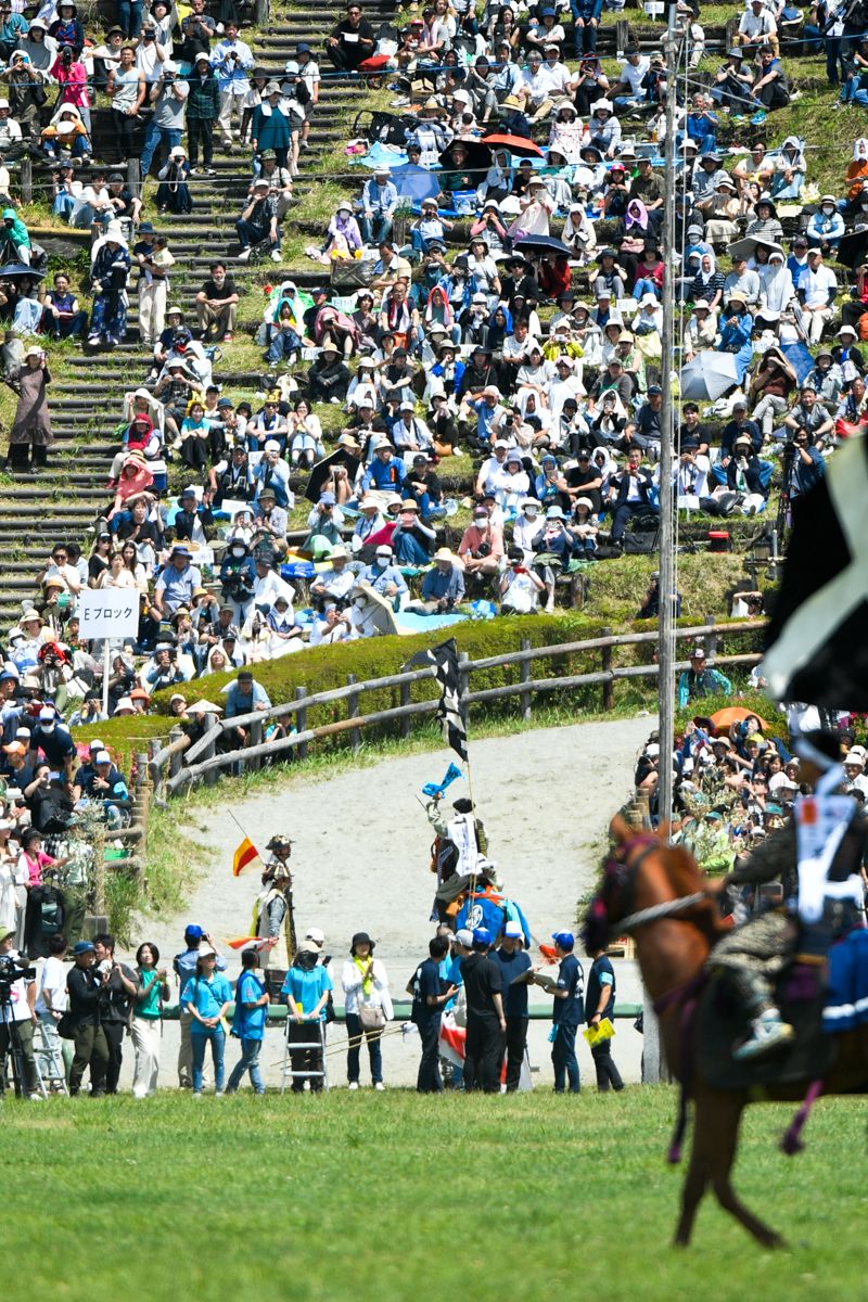 神旗争奪戦で一番旗を勝ち取った中頭を務めた大熊町騎馬会長小野田さんは「雲雀ケ原祭場地で神旗を取ったのは出場以来初めてのこと。一番旗だったことも含めて自分自身でも信じられない。一生に一度の経験をさせてもらった」と喜びを述べました。写真は誇らしげに一番旗を掲げる小野田会長。