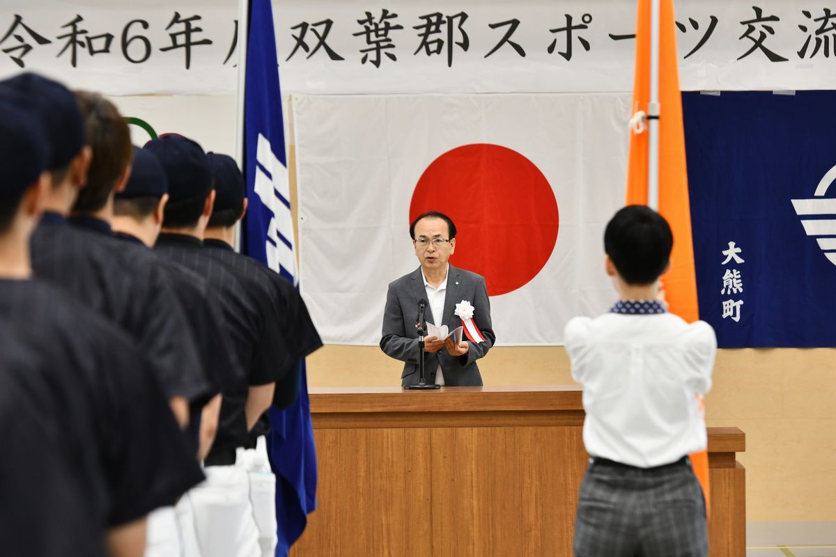 大熊町チームは6競技すべてに出場。ソフトテニスは優勝、グラウンド・ゴルフは準優勝の好成績を収めました。写真は、開会式で大会会長あいさつを述べる吉田町長