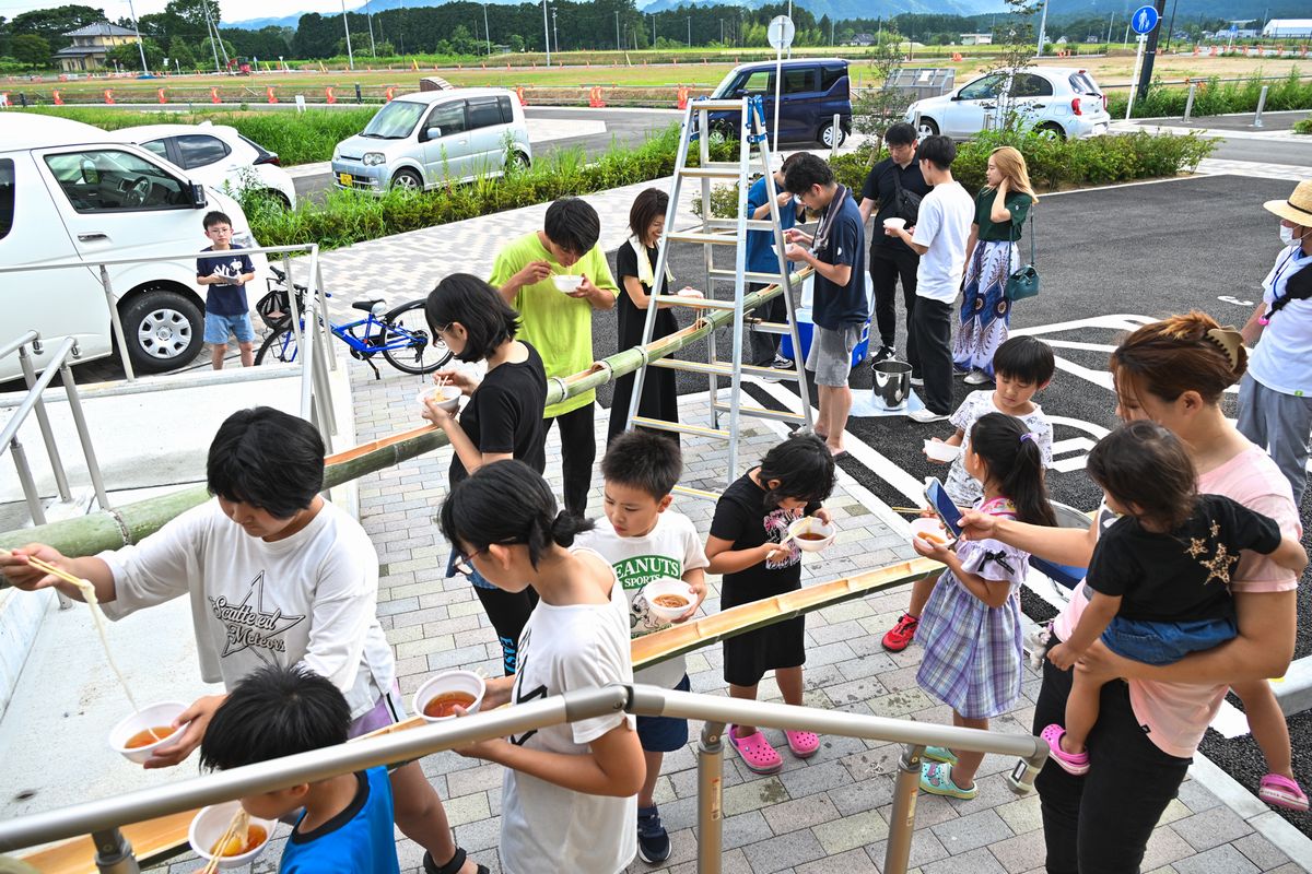 流しそうめんを楽しむ参加者ら