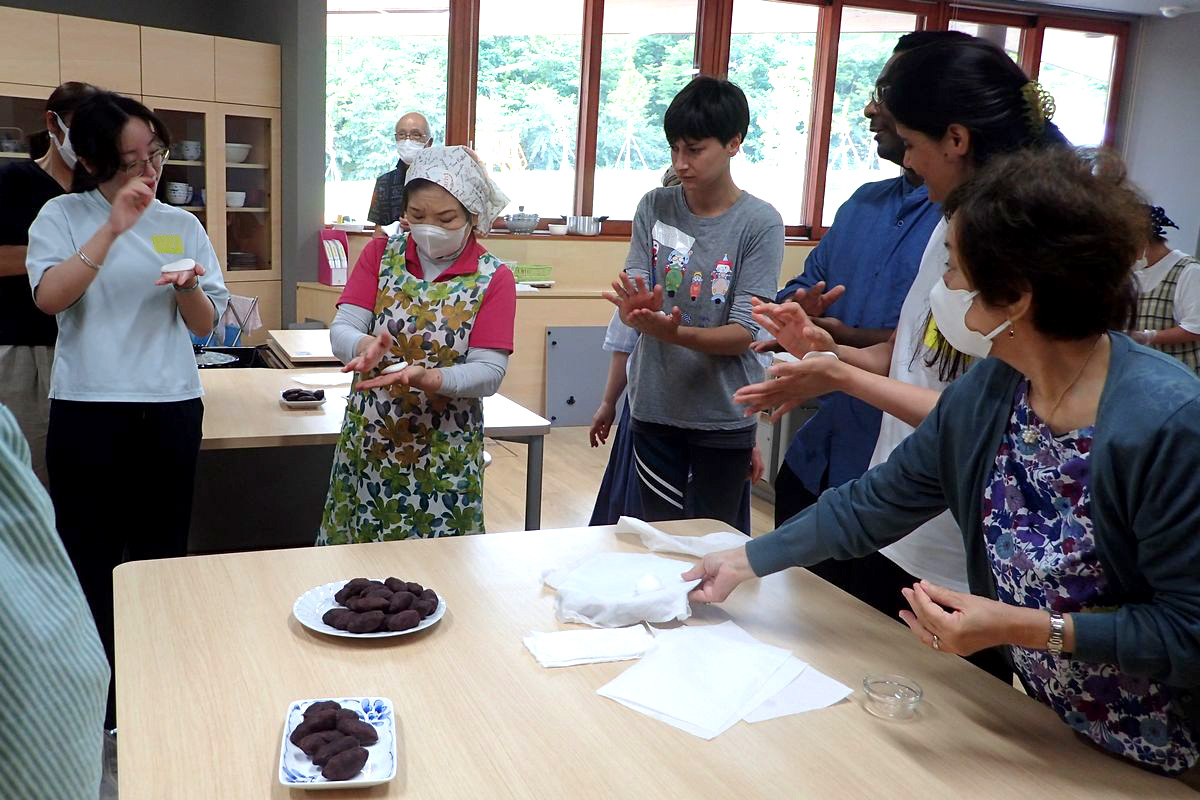 柏餅1個分にカットされた生地を手で軽く潰し、手のひらで薄く延ばします。