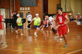 鬼ごっこをする児童と選手の写真