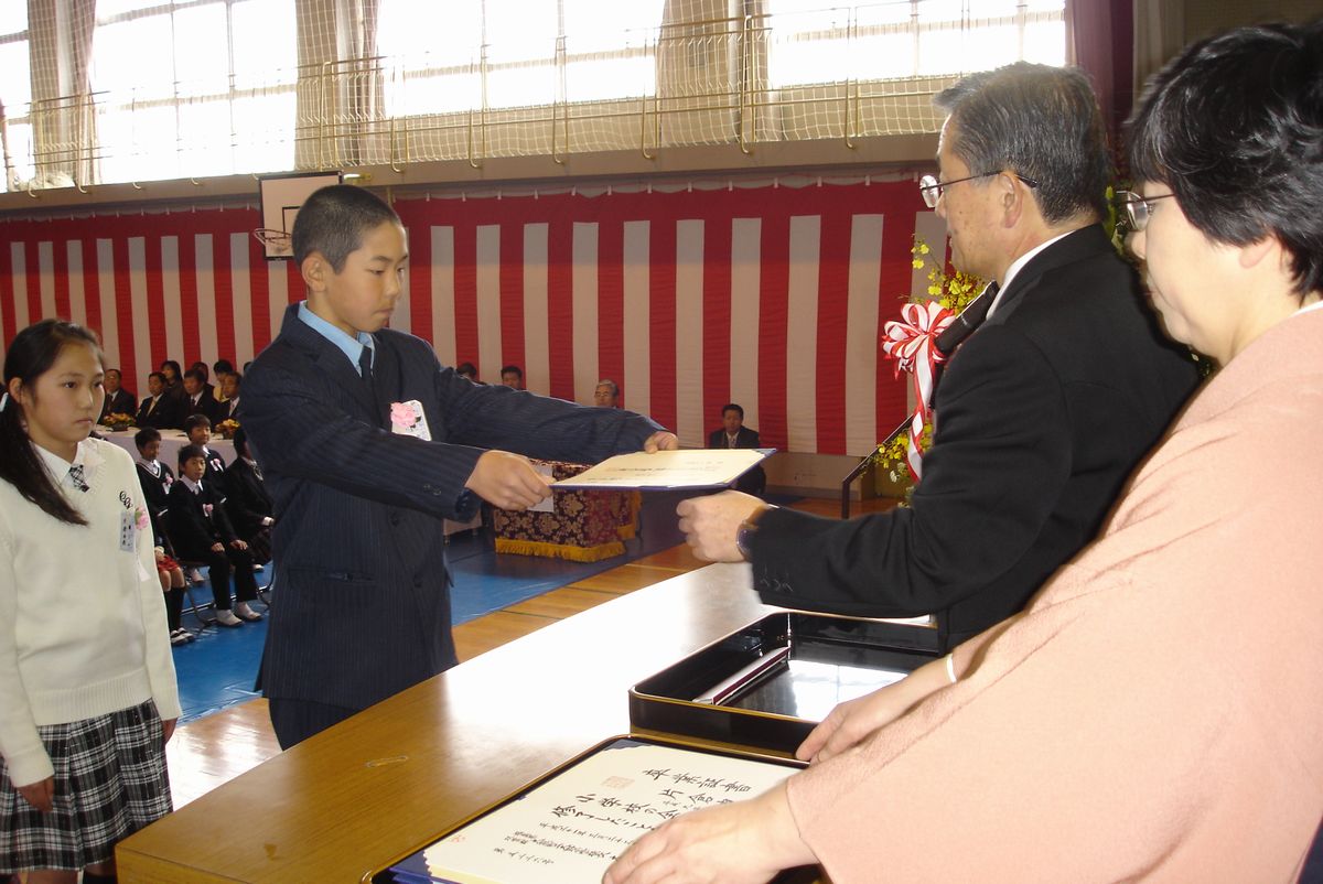 緊張の面持ちで登壇し卒業の喜びを噛みしめるように卒業証書を受け取る卒業生