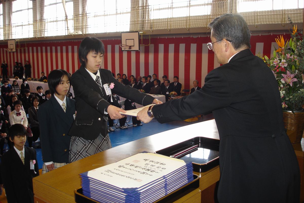 壇上で校長先生から卒業証書を受け取る卒業生