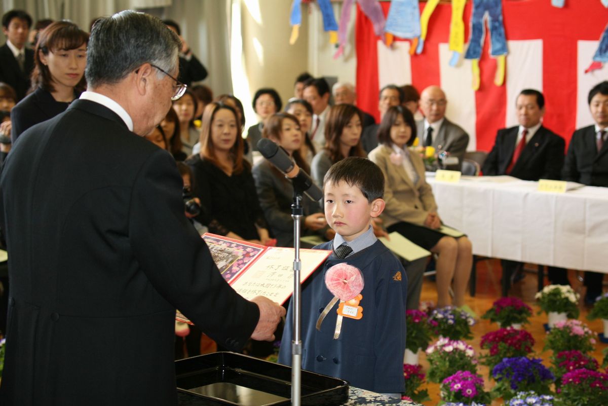 嬉しいような寂しいような表情で園長先生から終了証書を受け取る卒園児