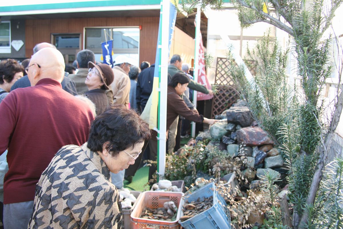 石和宝飾研磨製作所で宝石の原石などを見学する参加者