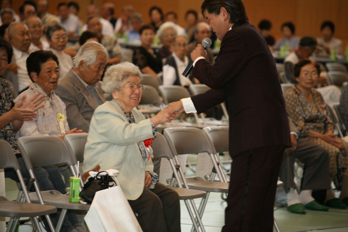 岬英二歌謡ショーで握手をする町民