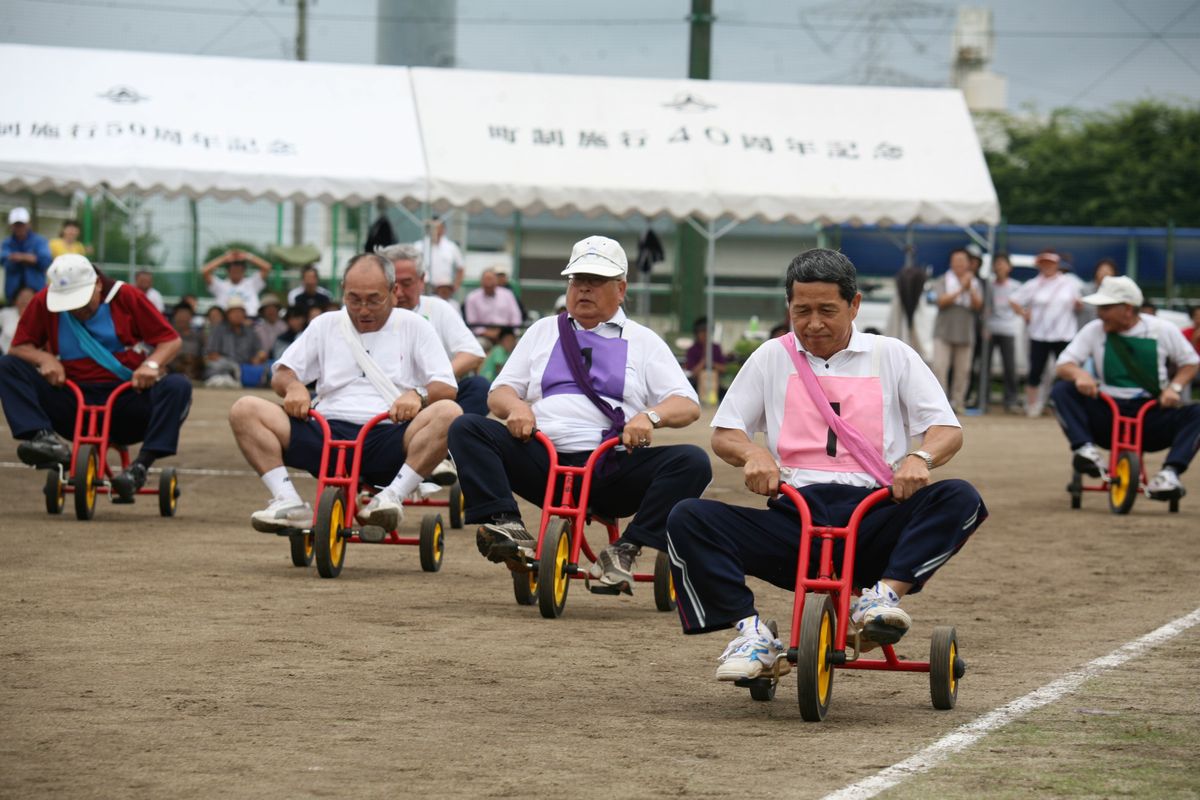 「鉄人リレー」小さな三輪車を一生懸命こいで優勝を狙うお父さんたち