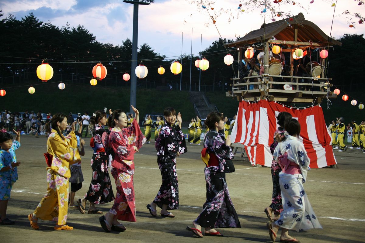 色とりどりの鮮やかな浴衣姿で盆踊りを踊る参加者