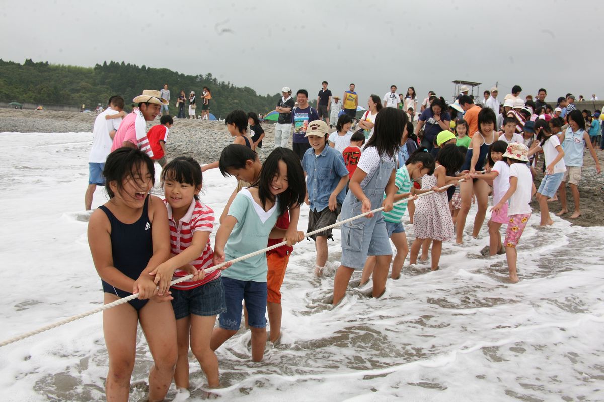 楽しそうに地引き網の網を引っ張る子どもたち