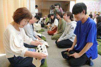 町民にトートバッグを手渡す学生