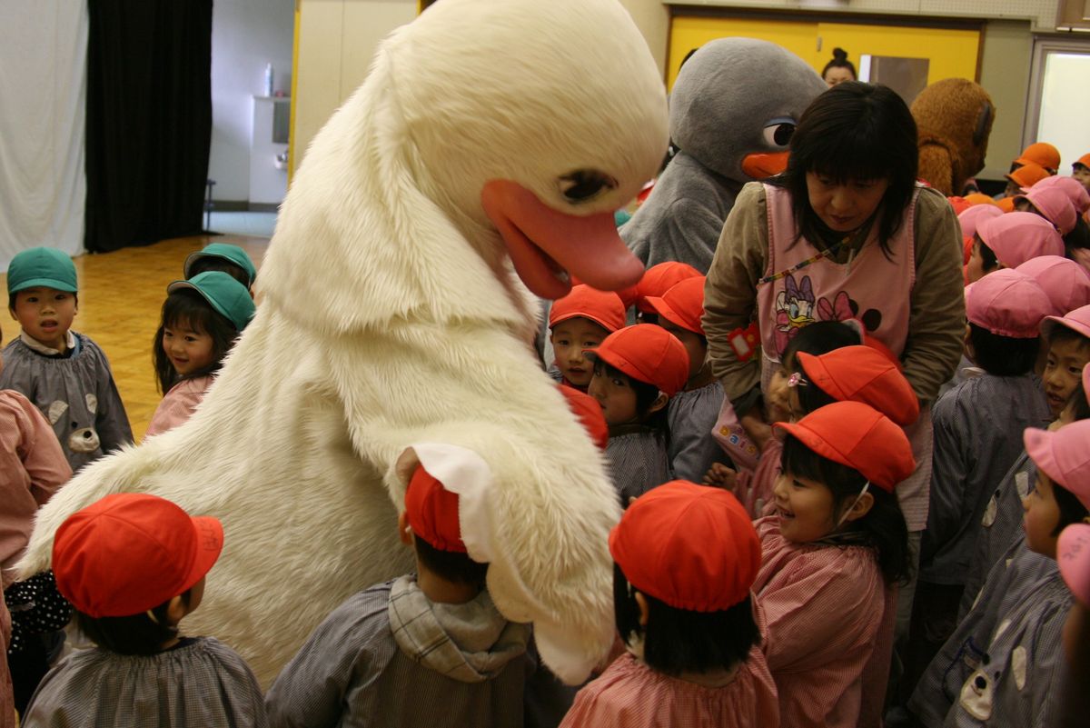 あひるや白鳥の人形と握手したり遊んだりして嬉しそうな園児たち