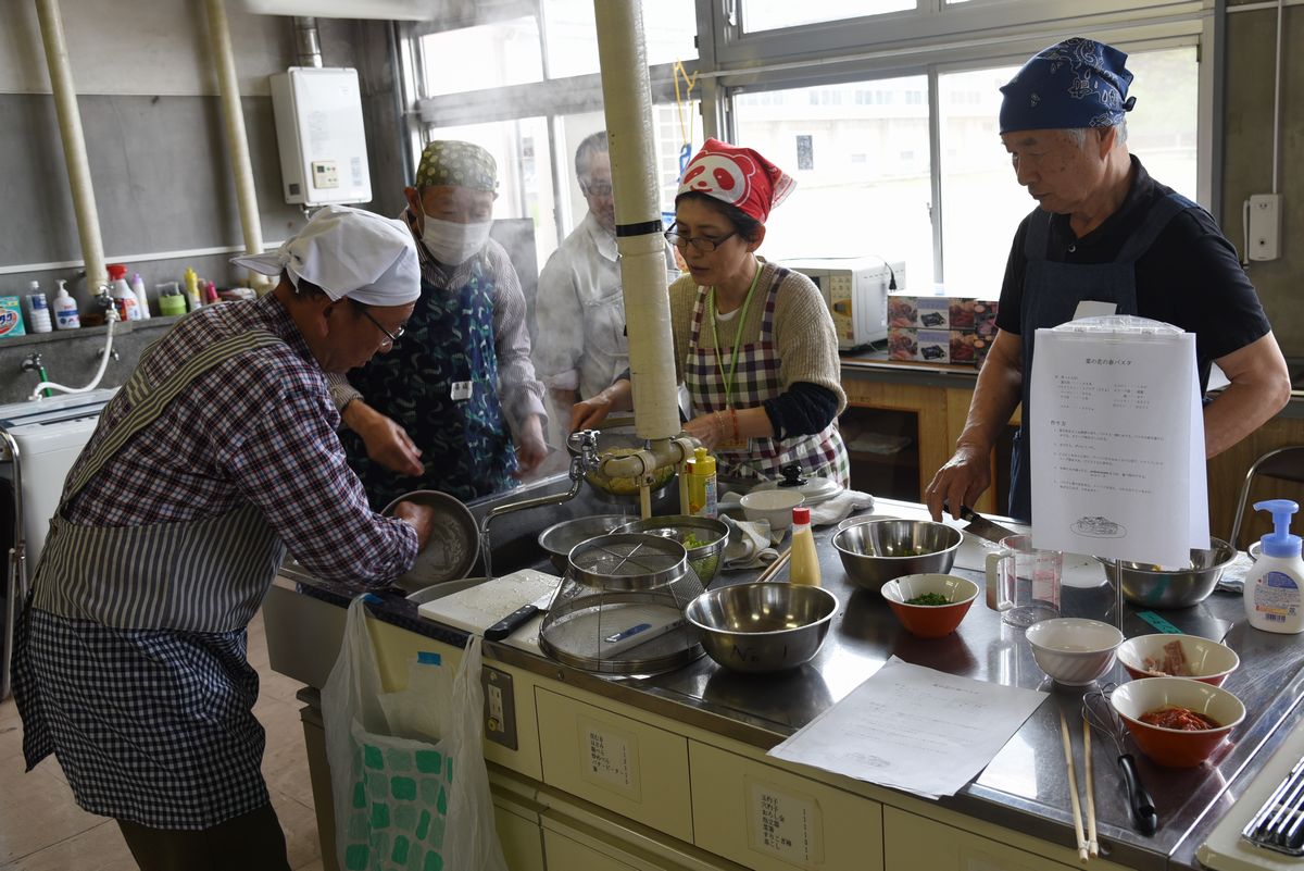 パスタの湯切りをする参加者