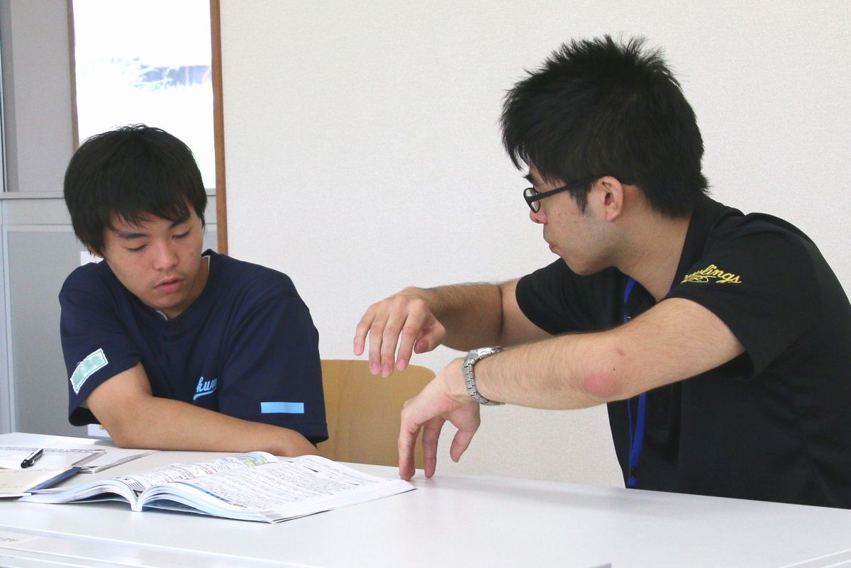 宿題や自主学習に取り組む中学生を付きっきりで指導する東大生