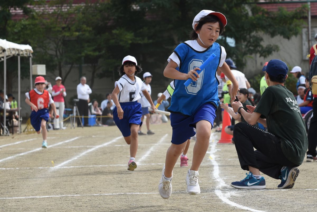 真剣な表情でチームの勝利を目指し駆ける児童