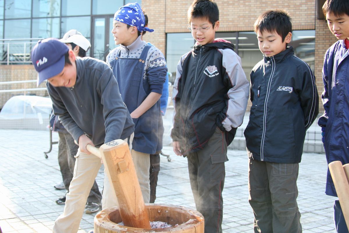 杵と臼を使い、力いっぱい餅つきをする子どもたち