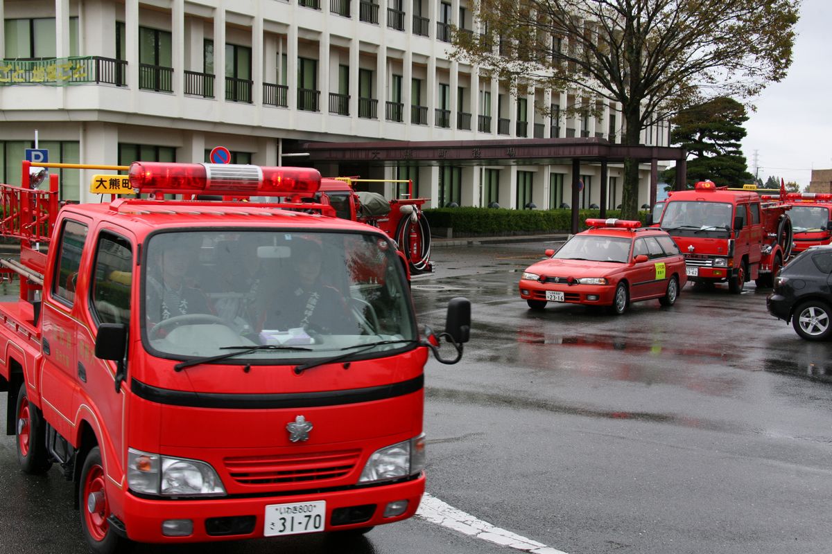 消防自動車に乗り、町内パトロールに出発する消防団員ら