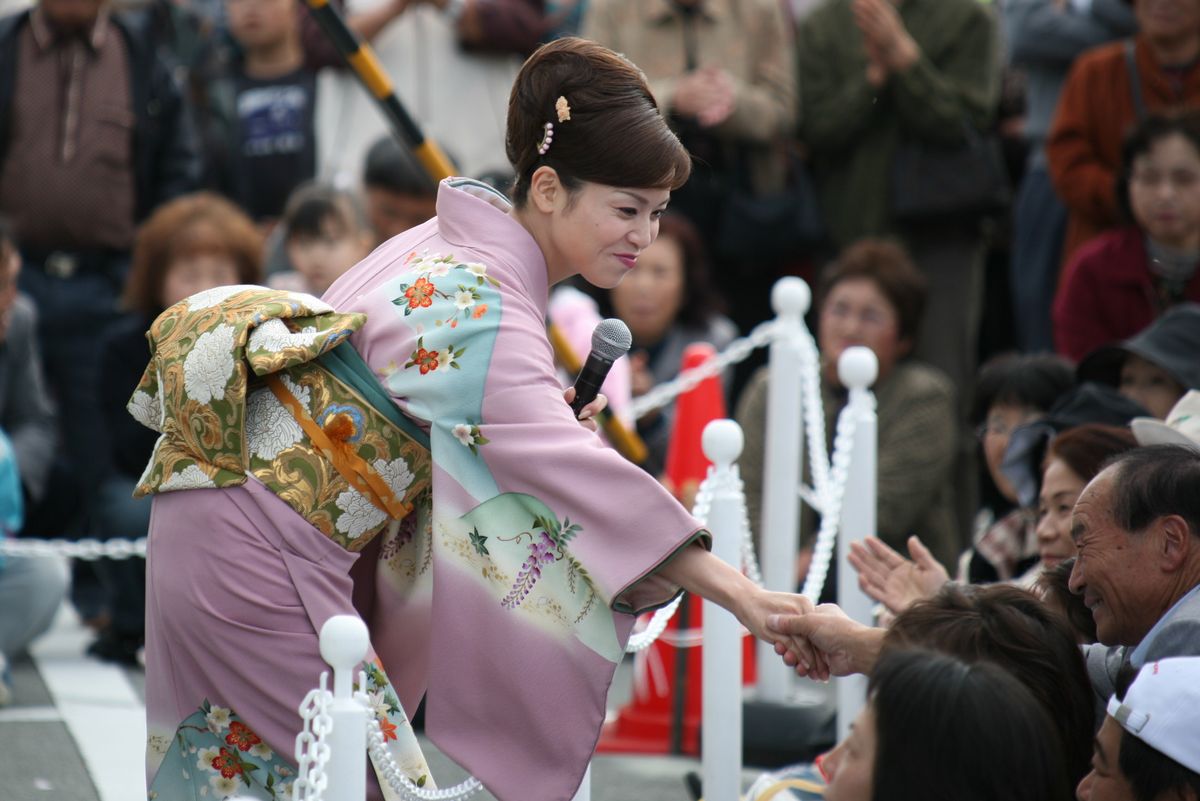 大歓声の中、来場者と握手しながら歌うゲストの石原順子