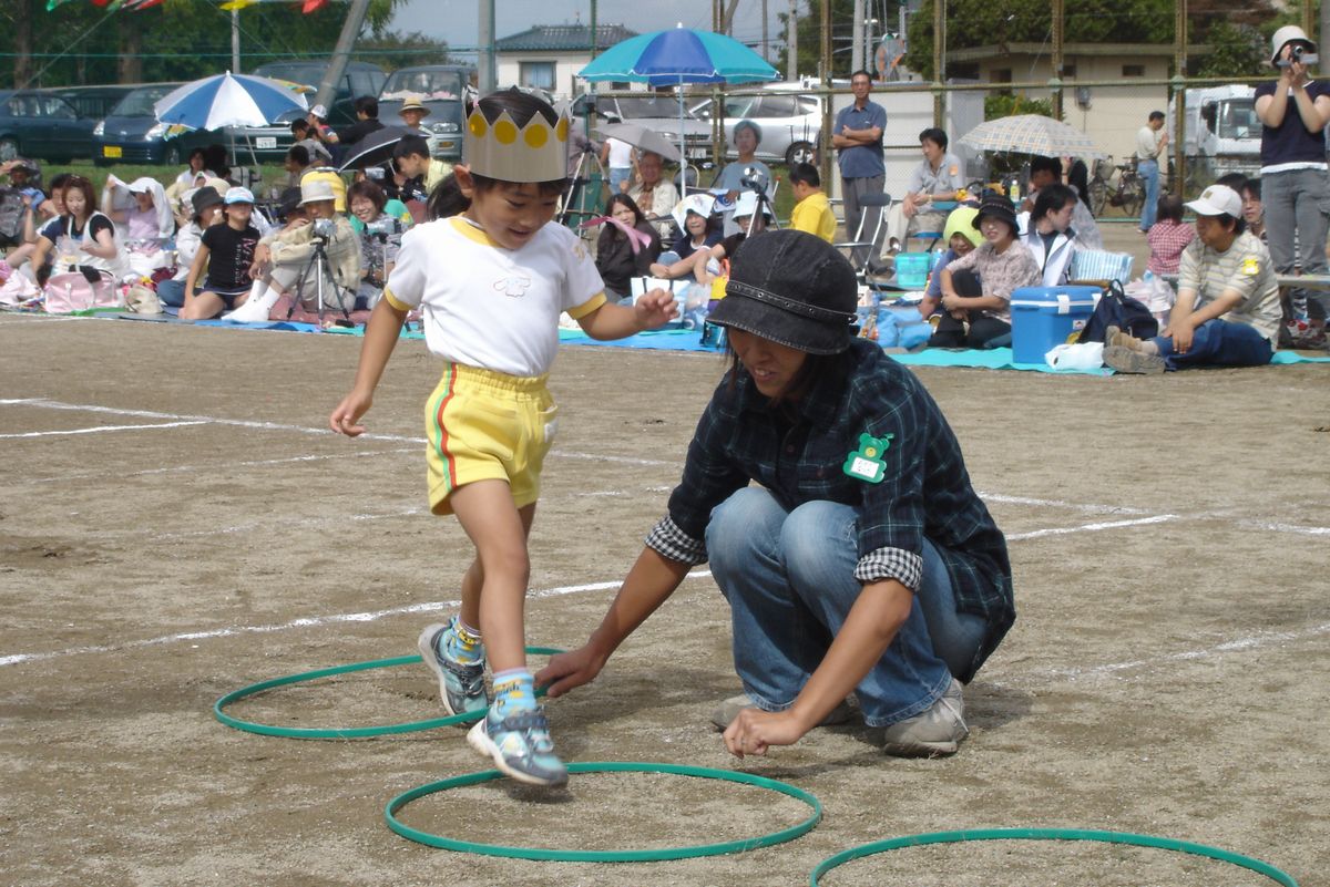 お母さんが並べた輪の中を次から次へと走る園児