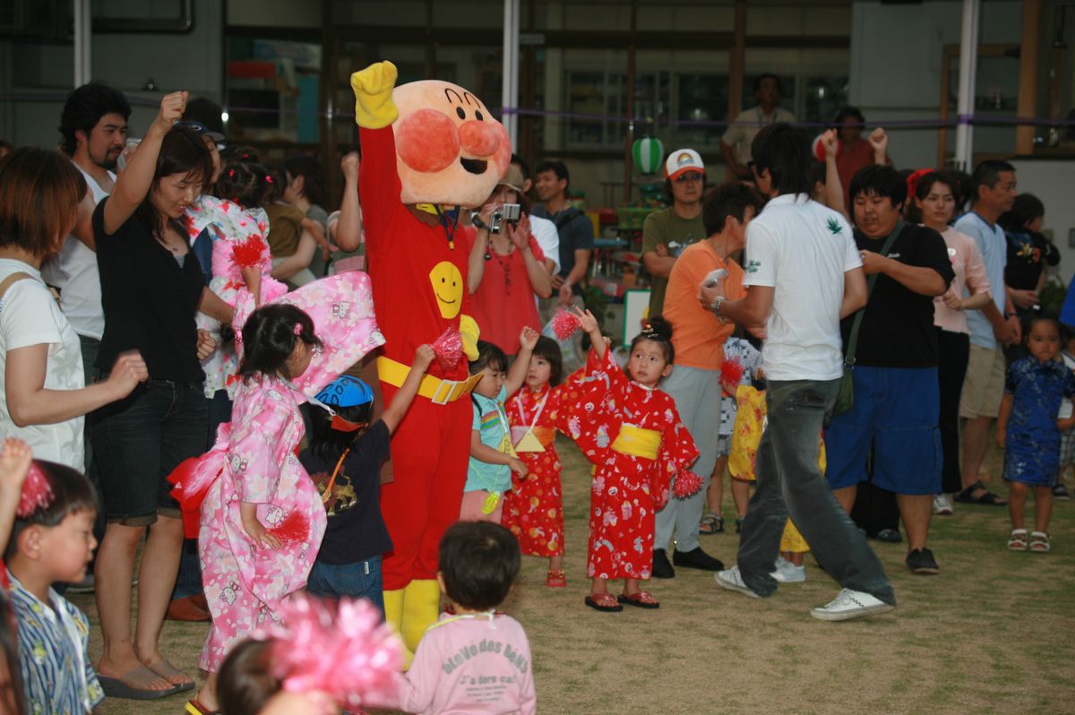 園庭で家族や先生、お友だちと踊る園児たち