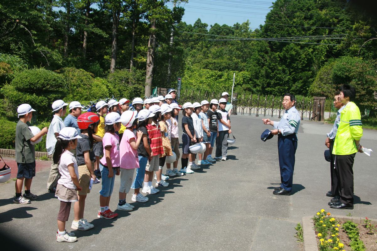 交通指導員の話を真剣に聞く児童たち