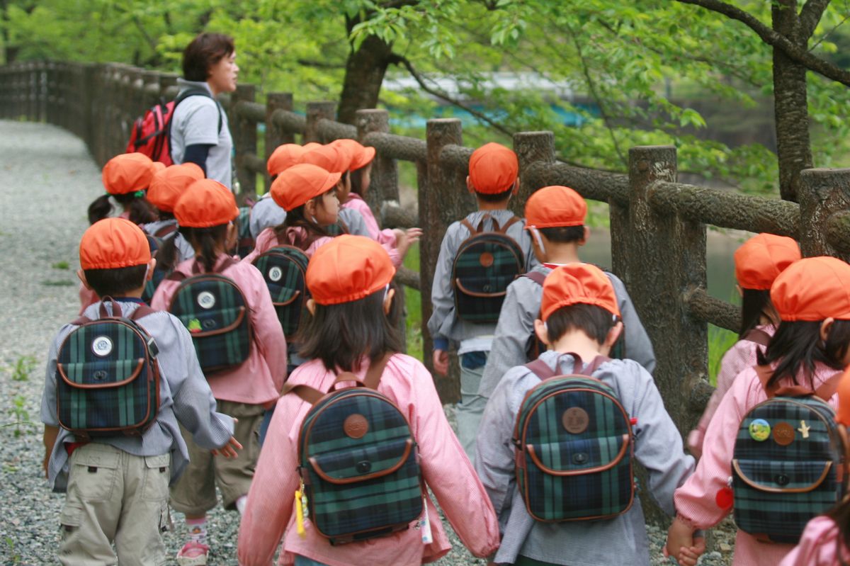 隣に並んだお友だちと手をつなぎ、ダムを見学する園児たち