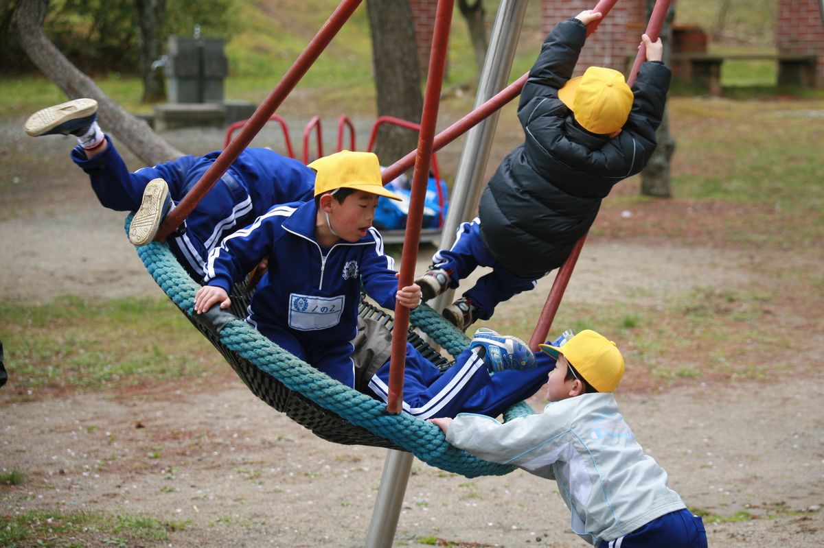 遊具でダイナミックに遊ぶ男子児童