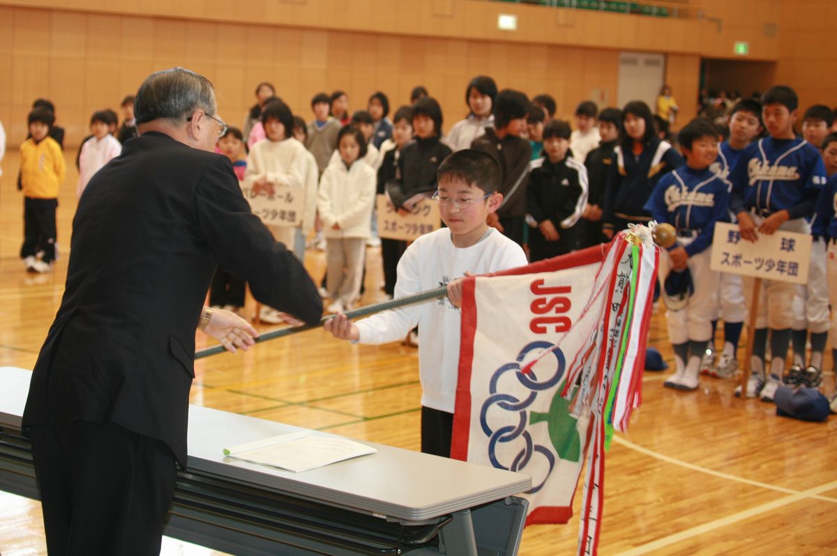 武内教育長から団旗を贈られる団員代表（2）