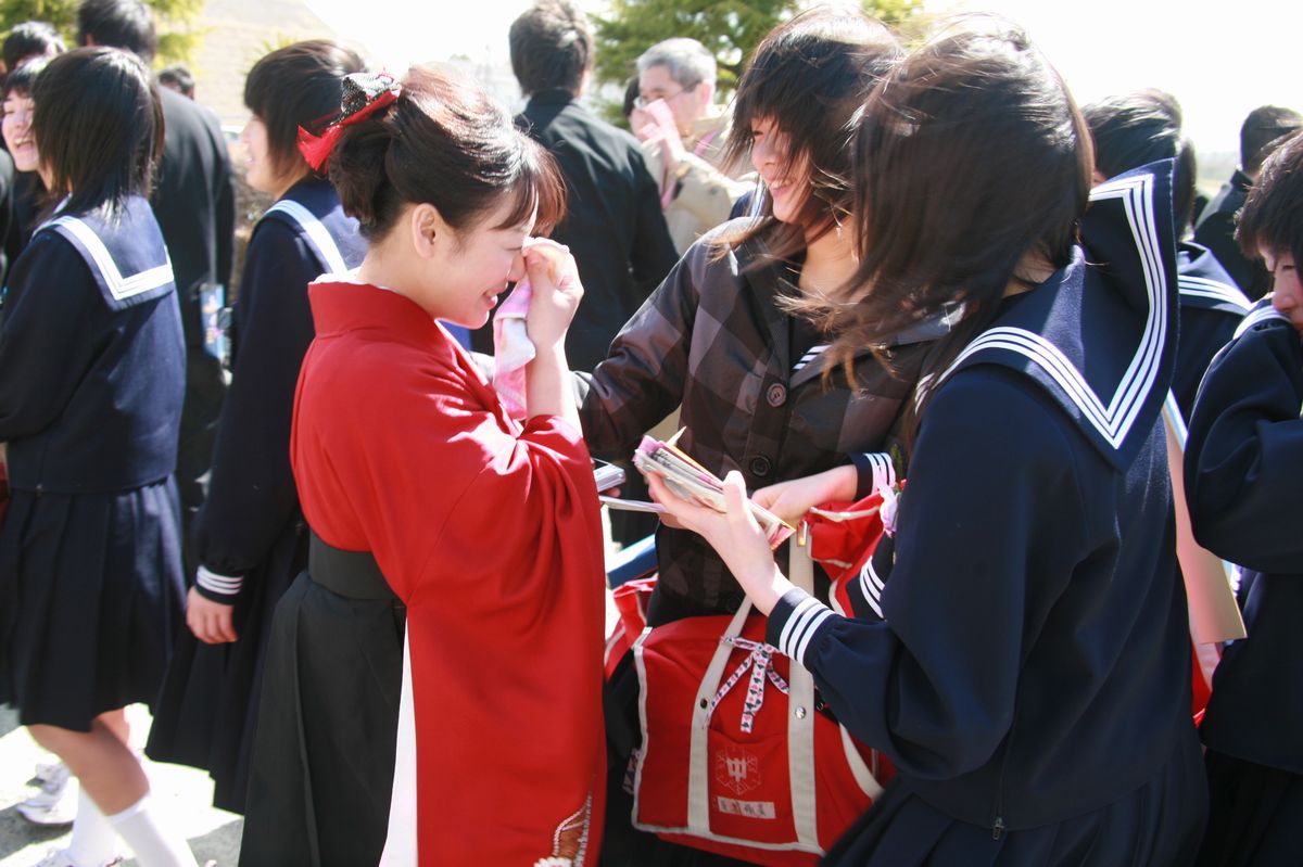 生徒たちとお別れの言葉を交わし涙を拭う先生