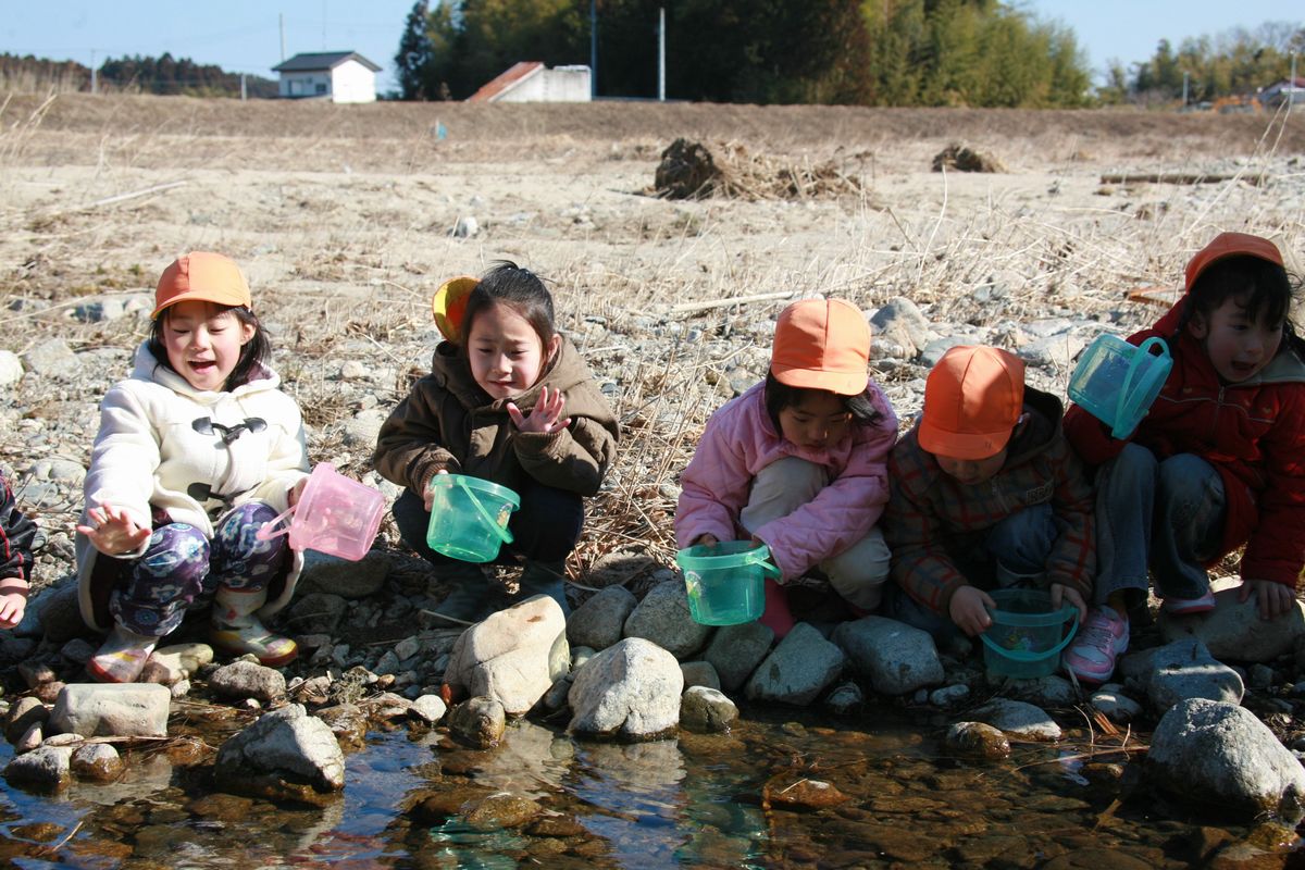 放流した稚魚に手を振ってさよならをする園児たち