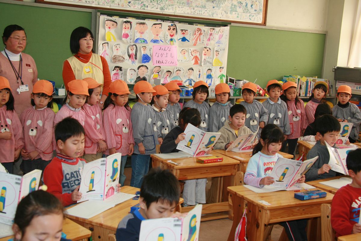 1年生が広げた国語の教科書に興味深々の園児たち