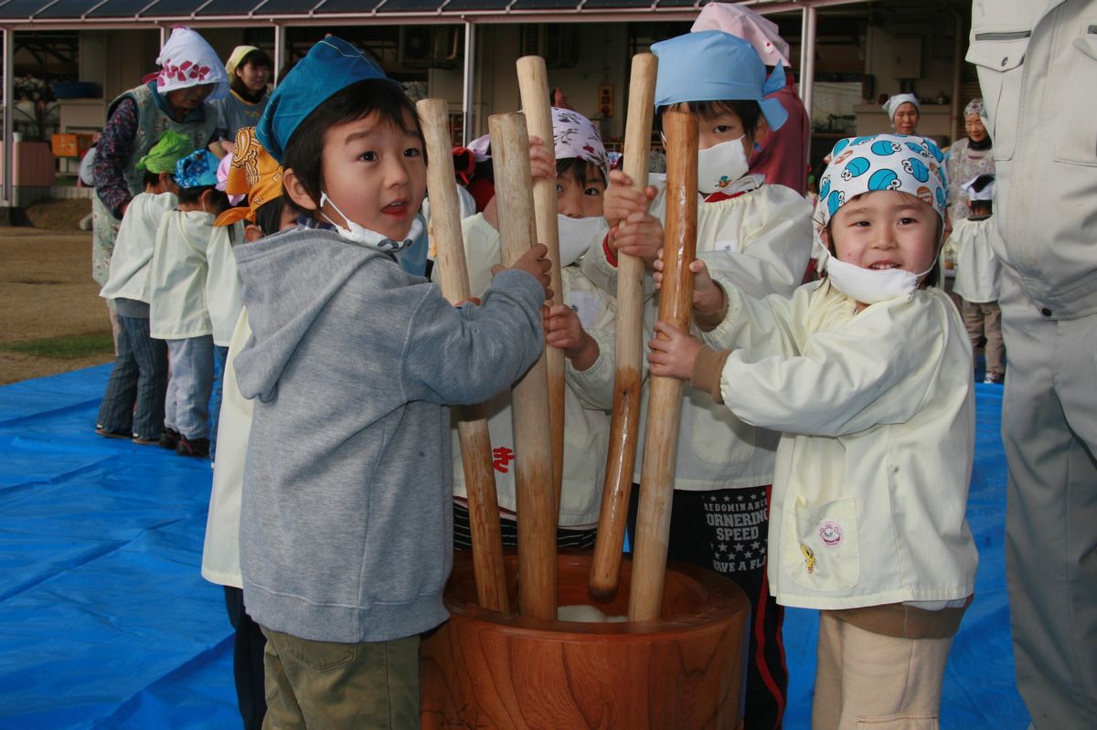 大きな臼と杵でもちつきを楽しむ子どもたち