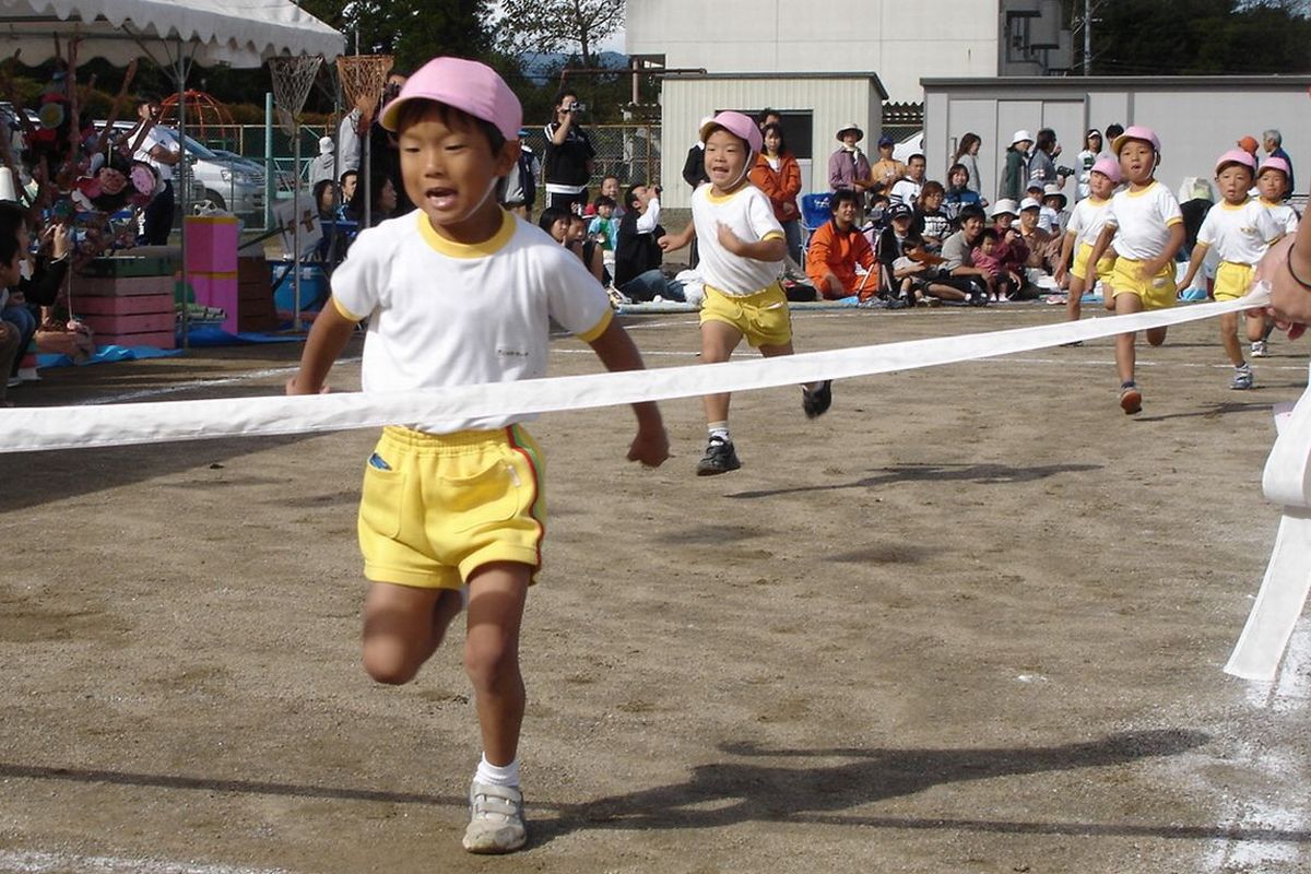 嬉しそうにゴールテープを切る園児