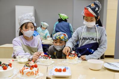 町立学び舎ゆめの森で12月18日、子どもたちがクリスマスケーキづくりに挑戦しました。町交流施設linkる大熊の主催で、子どもたち一人一人がクリスマスケーキをデコレーションしました。講師は町民でパティシエの池田未帆さんです。写真は、ケーキの飾り付けをする児童らの様子。