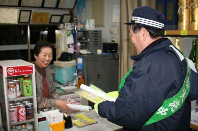 防犯協会長の渡辺町長から飲酒運転根絶のチラシを受け取る飲食店の方