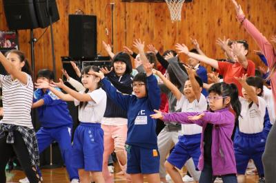 曲に合わせて両手を上げ躍動する生徒や町民の皆さん