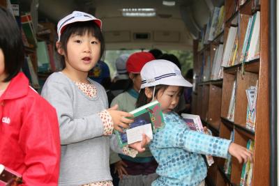 所狭しと並ぶたくさんの本の中から、読みたい本を探す児童