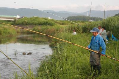 釣り竿をかまえ、鮎に目を光らせる釣り人たち