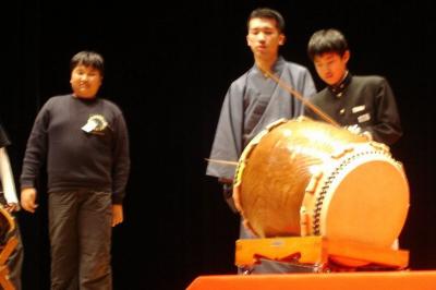 舞台上で、寄席の鳴り物の太鼓をたたく子どもたち